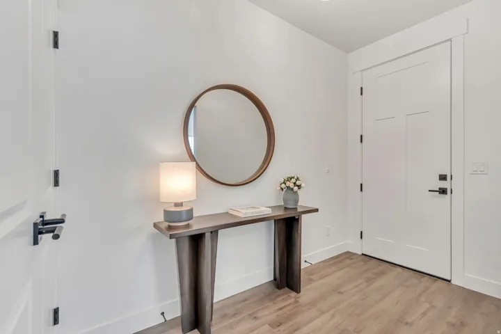 Entryway featuring light wood-finish flooring, white walls, and a modern console table