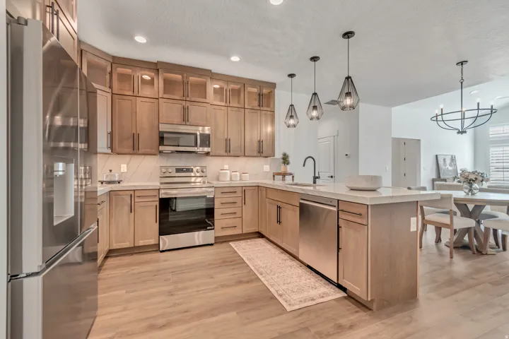 Open-concept kitchen featuring wood-finish flooring and light wood cabinetry