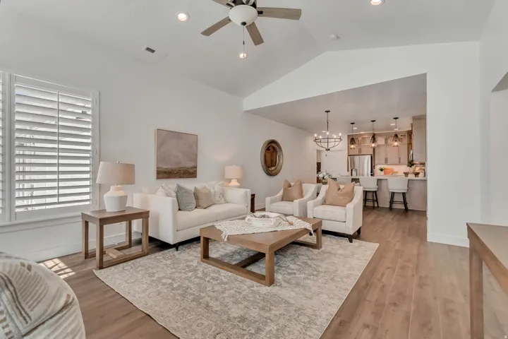 Living area featuring vaulted ceilings, recessed lighting, and wood-finish flooring