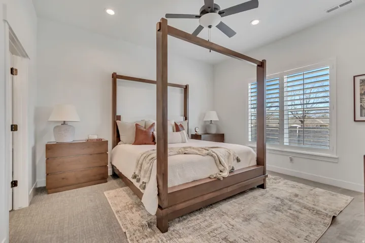 Recessed lighting, ceiling fan, and large windows with plantation shutters