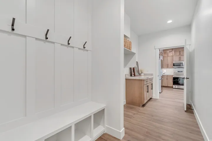 Entryway featuring a built-in bench with storage cubbies and wall-mounted hooks