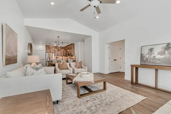 Vaulted ceiling living area featuring wood-finish flooring and recessed lighting