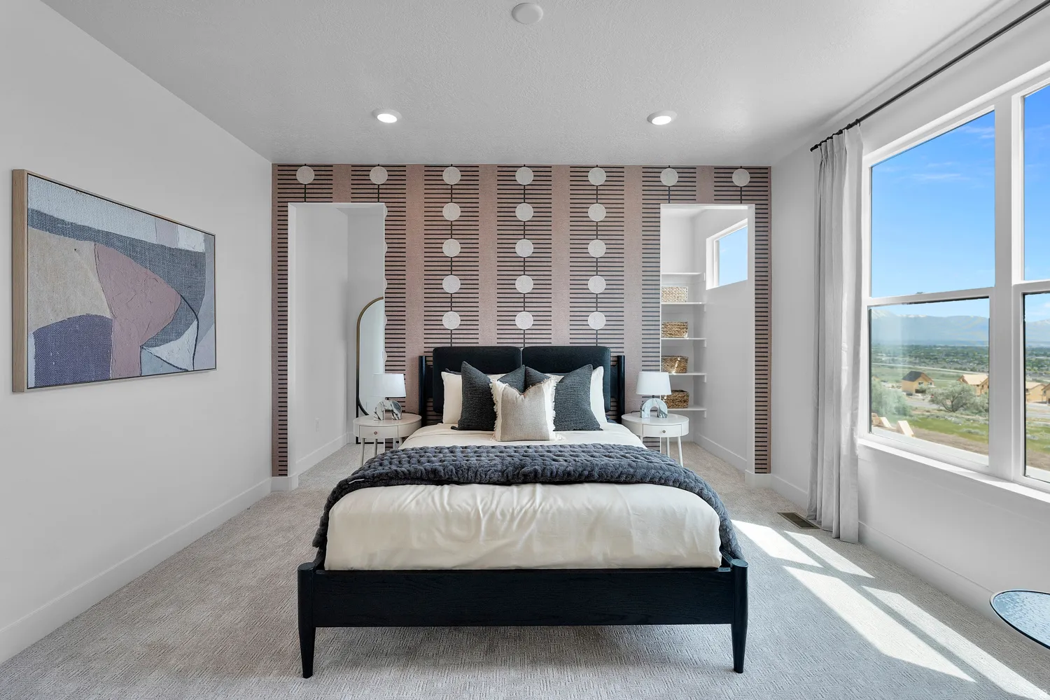 Spacious bedroom featuring light-toned carpet flooring and a large window