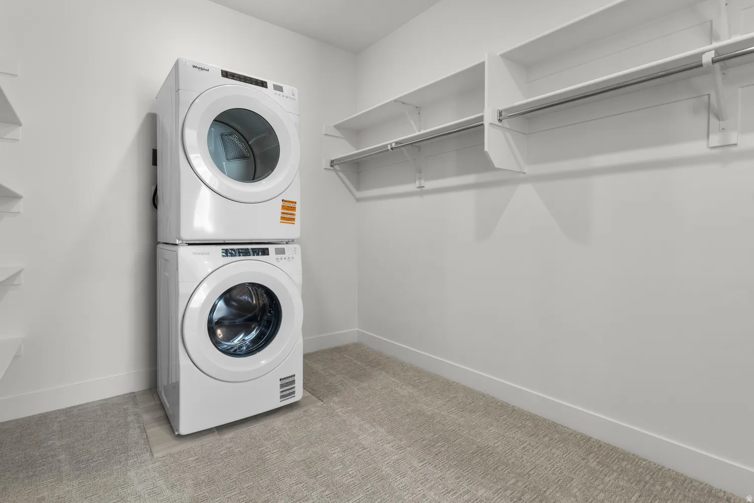 Dedicated laundry area featuring a stacked washer and dryer unit