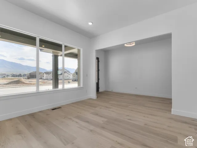 Large windows with mountain scenery, wood-finish flooring, and recessed ceiling lighting