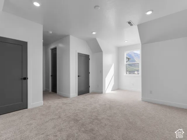Interior space featuring wall-to-wall carpeting, recessed ceiling lighting, and solid-core interior doors with matte black hardware
