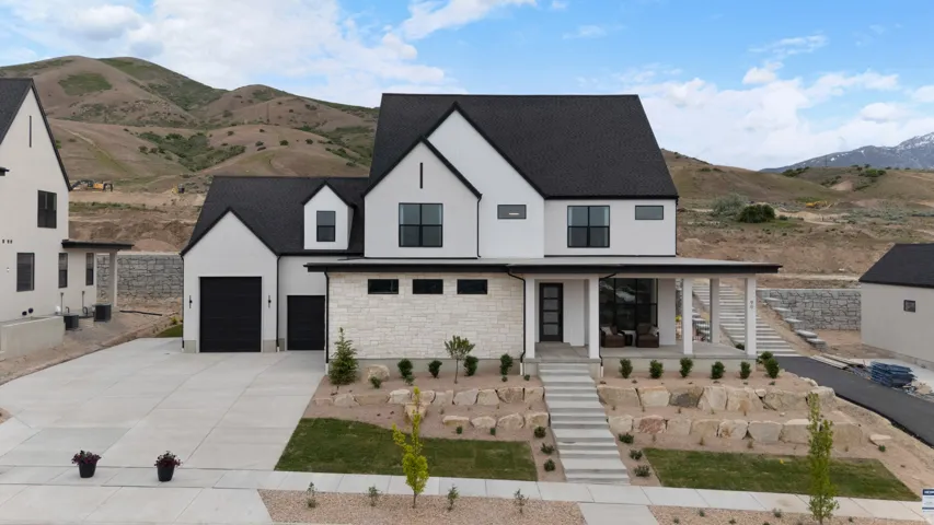 Contemporary home featuring a striking black and white exterior with a stone accent facade