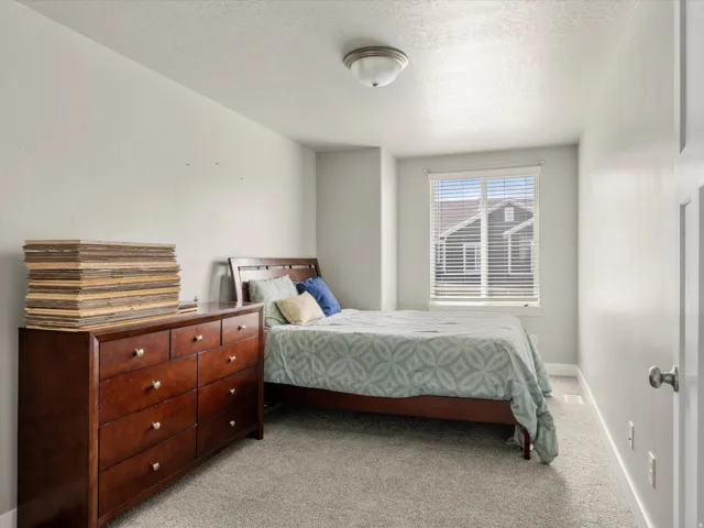 Carpeted room featuring a window with horizontal blinds, neutral wall paint, and a semi-flush mount ceiling light fixture