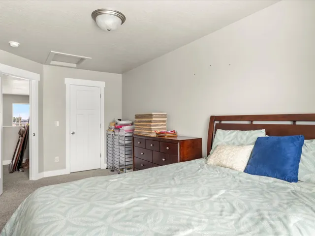 Bedroom featuring light gray wall paint, recessed ceiling with a flush mount light fixture, and a white three-panel door
