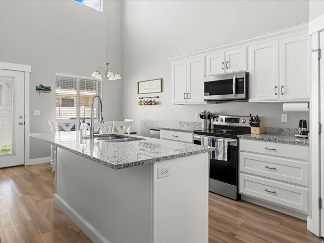 Modern kitchen featuring a central island with an undermount sink and gooseneck faucet