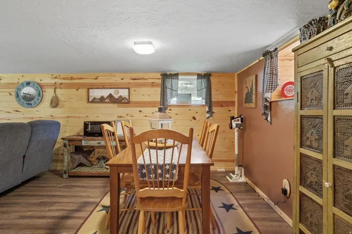 Wood-finish flooring anchors this dining area featuring wood plank wall accents and a contrasting accent wall