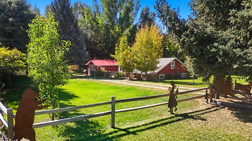 Expansive green lawn framed by a split-rail fence