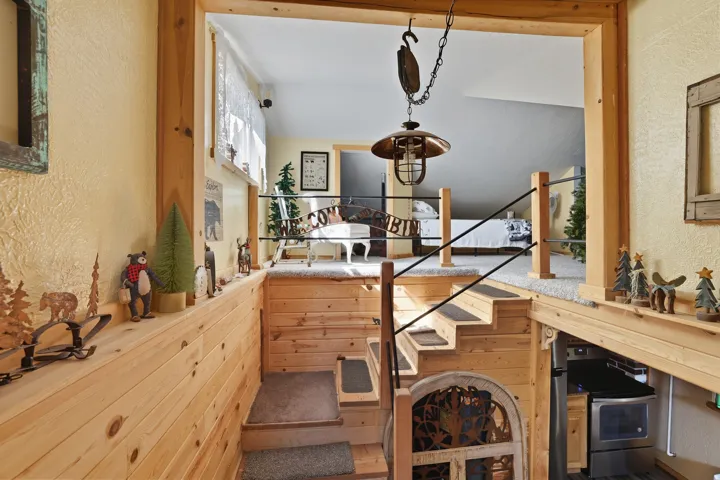 Split-level interior featuring wood plank walls and staircase
