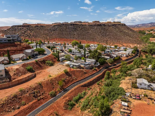 Terraced community featuring a paved road system, integrated into a high desert landscape with prominent rock formations