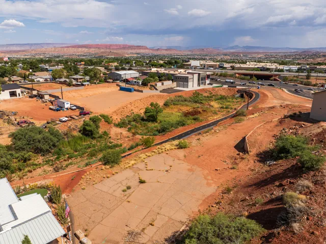 Expansive land parcel featuring varied terrain, a concrete pad, and scattered vegetation