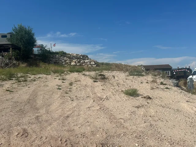 Sloping terrain with a visible rock retaining wall