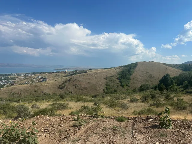 Expansive hillside property featuring distant water body and surrounding community
