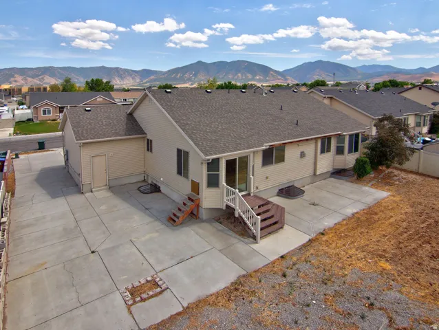 Rear exterior featuring a concrete patio, access to the interior via a sliding glass door, and an exterior staircase