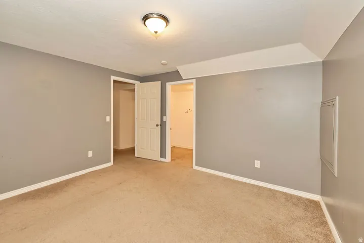 Carpeted room with neutral gray walls and white trim