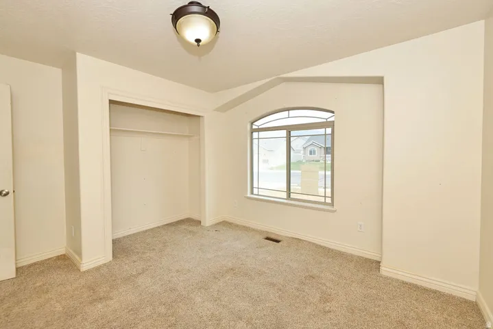 Neutral tone wall paint with a built-in closet featuring shelving and hanging rod