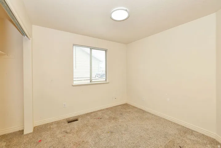 Room featuring a window with a white frame, baseboard molding, and light-colored carpet