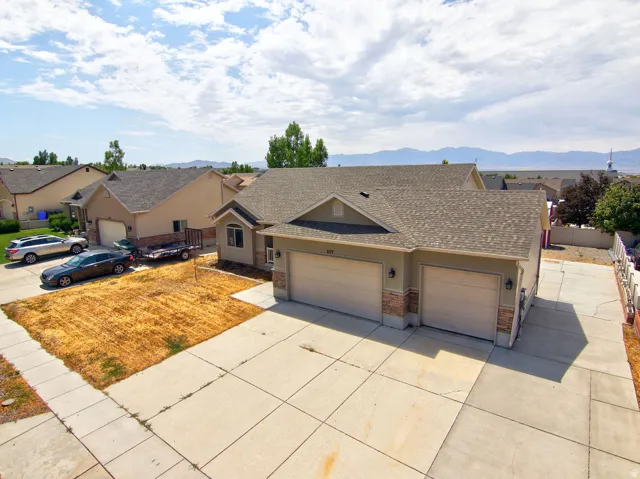 Suburban residence featuring a two-car garage, stone facade accents, and a concrete driveway