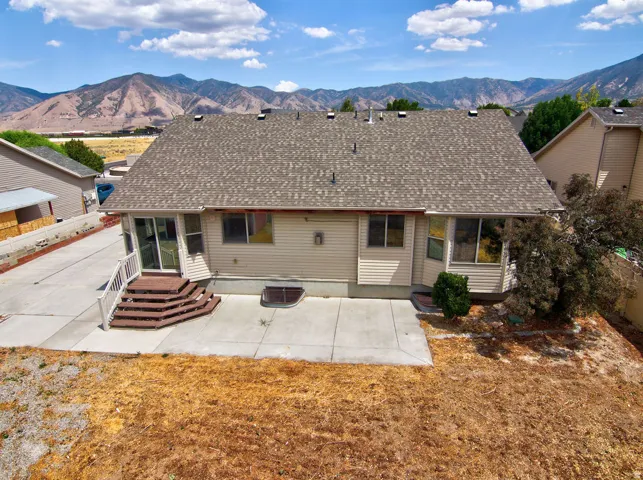 Rear exterior with a concrete patio and multi-tiered deck with white railings