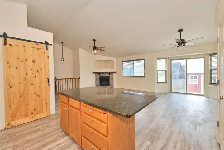 Kitchen island with granite-style countertop and wood cabinetry