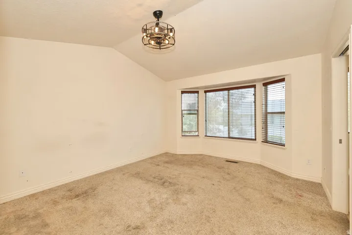 Room featuring a vaulted ceiling and a contemporary semi-flush mount light fixture