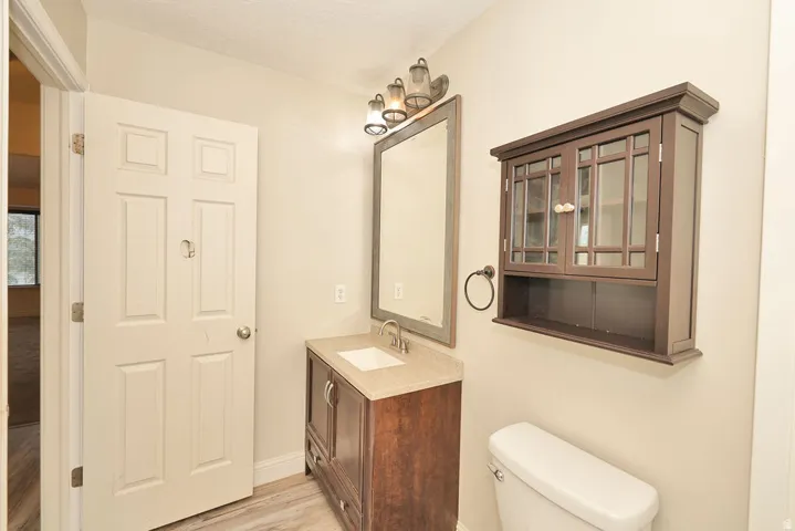 Bathroom vanity featuring a single sink, light-toned countertop, and dark wood-finish cabinetry