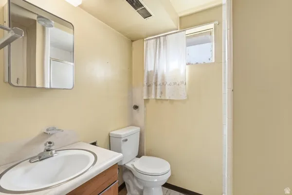 Compact bathroom featuring a window, built-in medicine cabinet, and a vanity with a drop-in sink