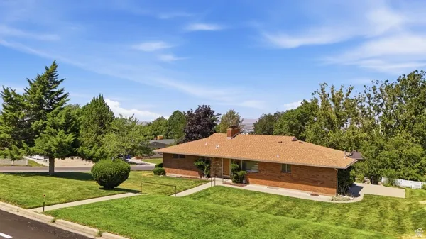 Ranch-style residence featuring a brick exterior and a brown shingle roof