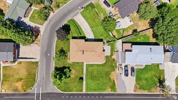 Aerial perspective showcasing a property with a brown shingle roof and green landscaping