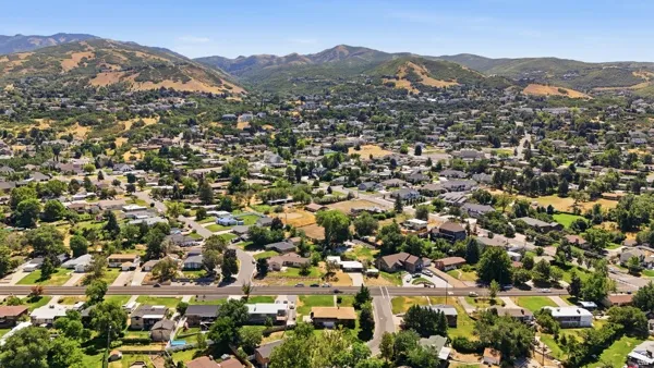 Expansive residential area with a prominent mountainous backdrop, featuring numerous single-story and multi-story homes