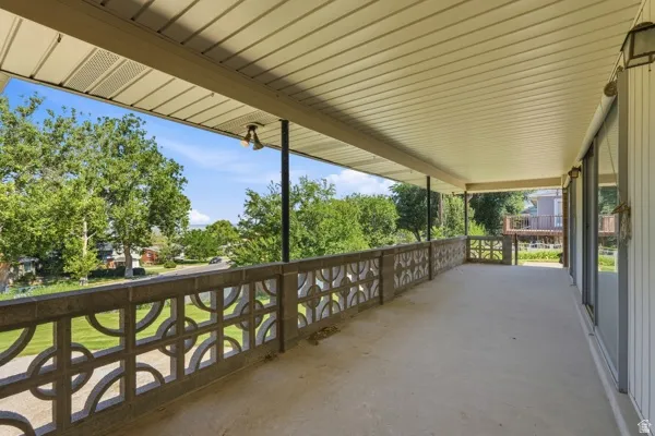 Expansive covered balcony featuring concrete flooring and a decorative block railing