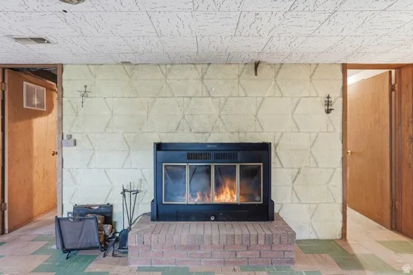 Fireplace insert with glass doors, set on a brick hearth