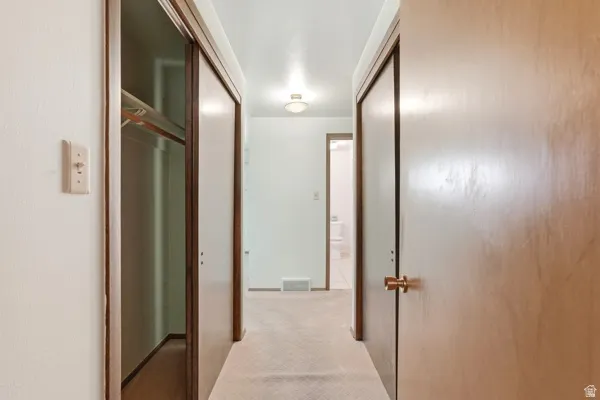 Hallway featuring carpet flooring and light-toned walls