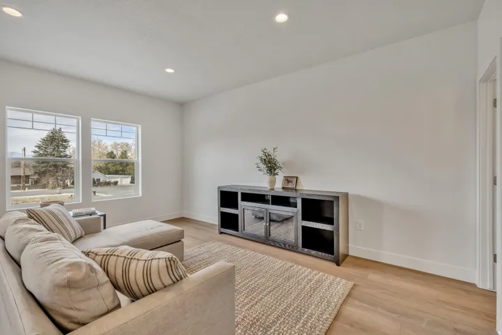 Open concept living area featuring light wood-finish flooring, recessed lighting, and white walls