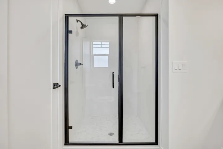 Shower enclosure featuring clear glass panels with matte black framing and hardware