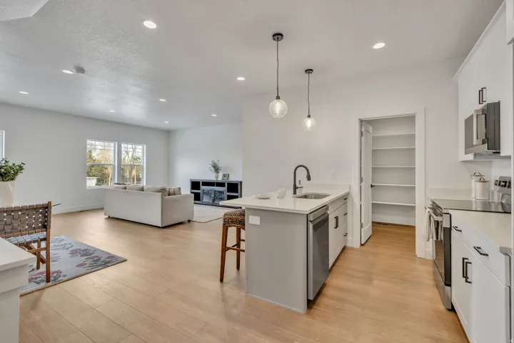 Open-concept living space featuring wood-finish flooring, recessed lighting, and large windows
