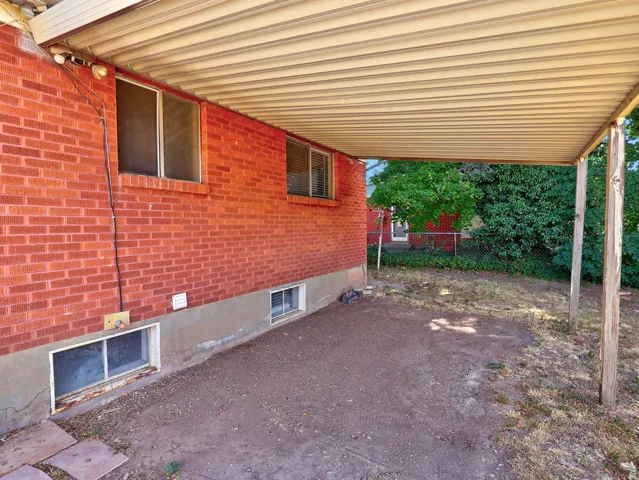 Covered patio area featuring a corrugated metal roof and exposed wooden support posts