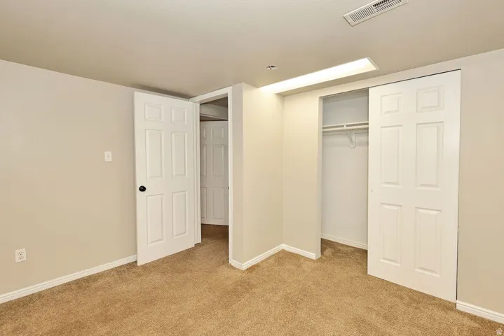 Carpeted room featuring light beige wall paint and white trim