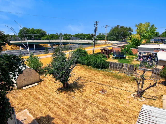 Expansive backyard with a storage shed and mature trees