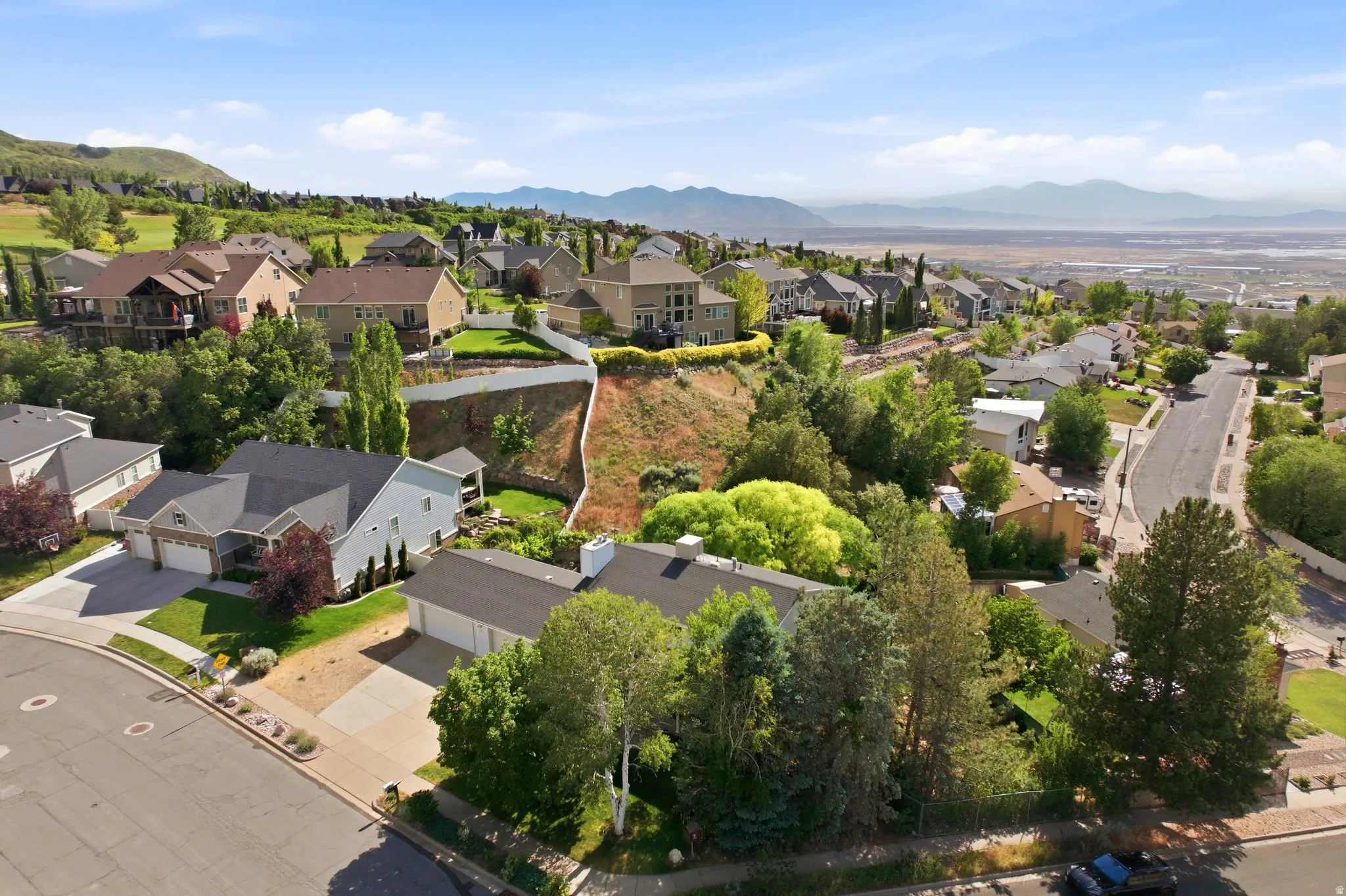 Residential neighborhood featuring a variety of architectural styles, mature landscaping, and paved streets