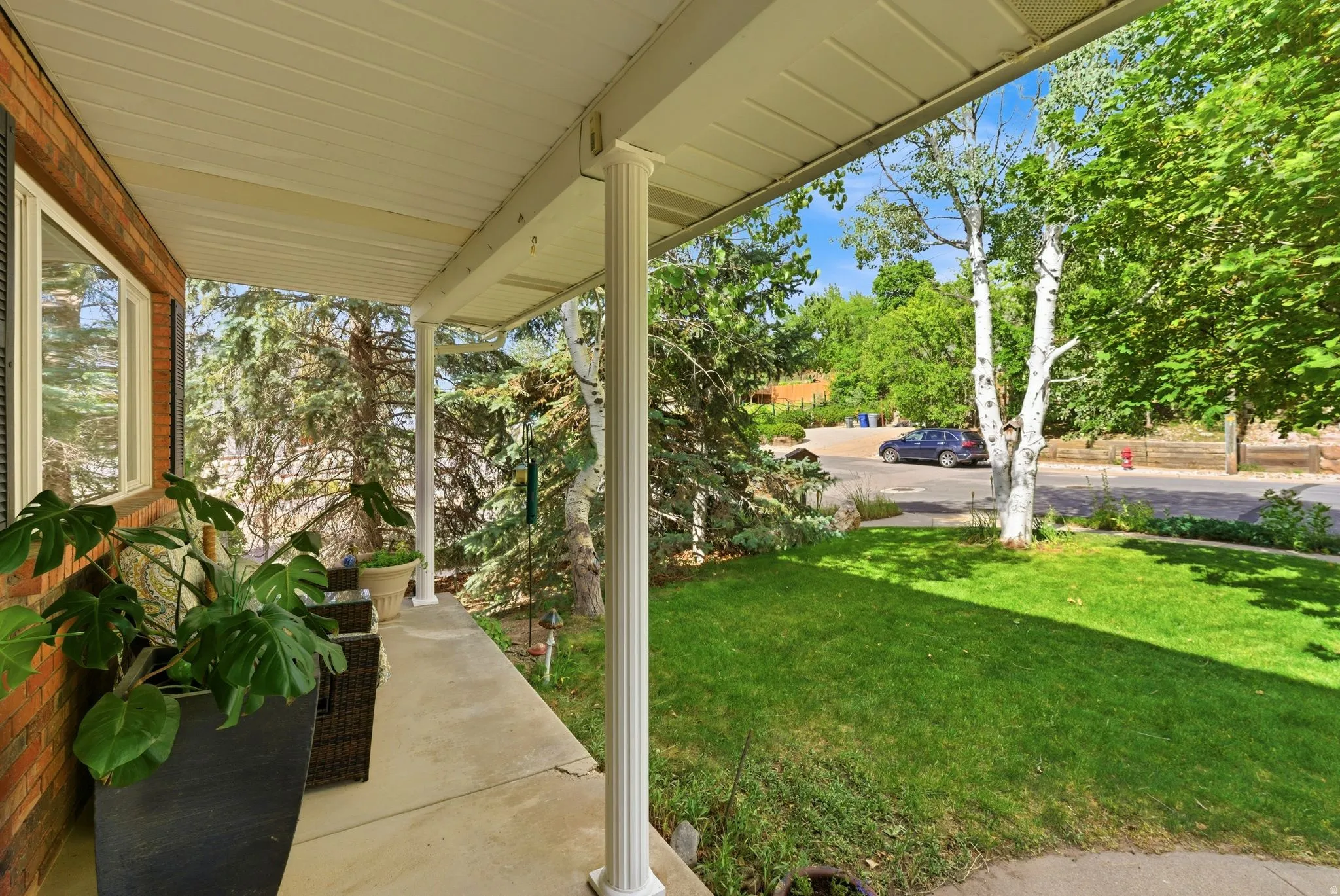 Front porch featuring a concrete surface and white support columns