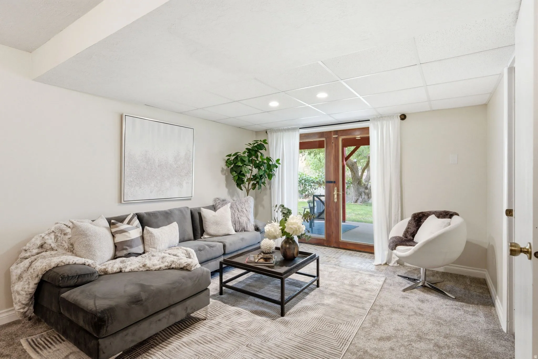 Finished basement space featuring recessed lighting, a drop ceiling, and neutral-toned carpet flooring