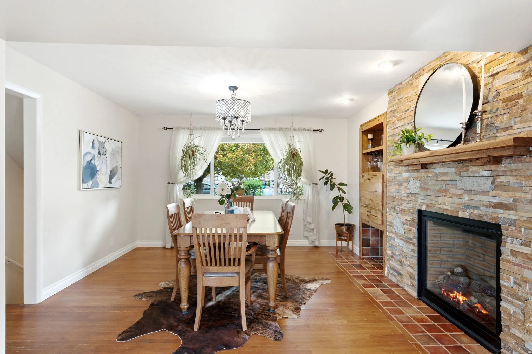 Stone-clad fireplace with a wood mantle and built-in shelving, featuring a tile hearth