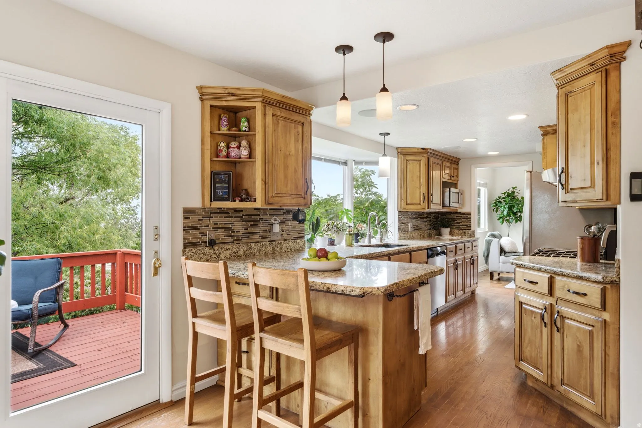 Kitchen with wood-finish flooring, light wood cabinetry, and granite countertops