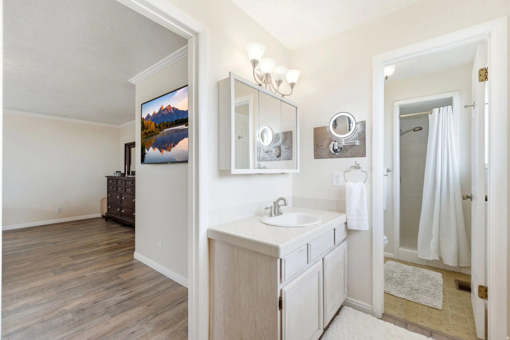 Bathroom vanity with a single basin sink and white tile countertop
