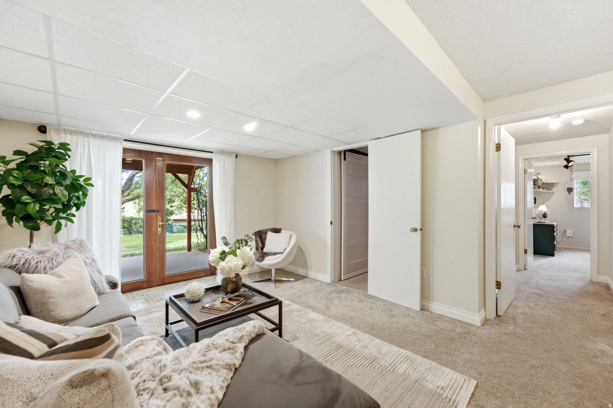 Carpeted living space with French doors opening to the exterior